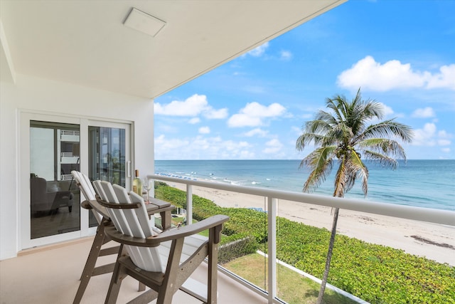 balcony featuring a water view and a view of the beach