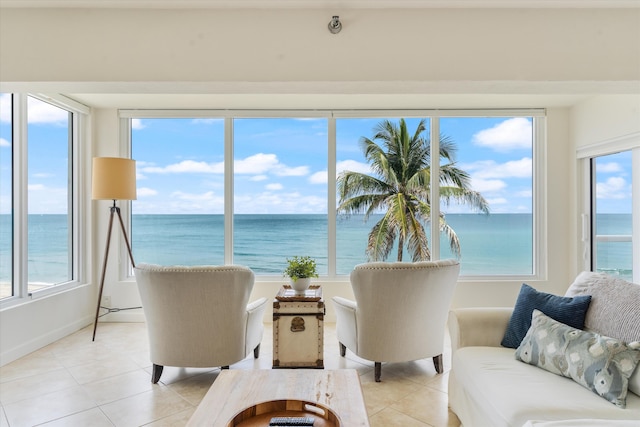 living area with light tile patterned floors, a water view, and plenty of natural light