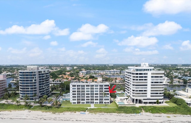 birds eye view of property featuring a water view and a beach view