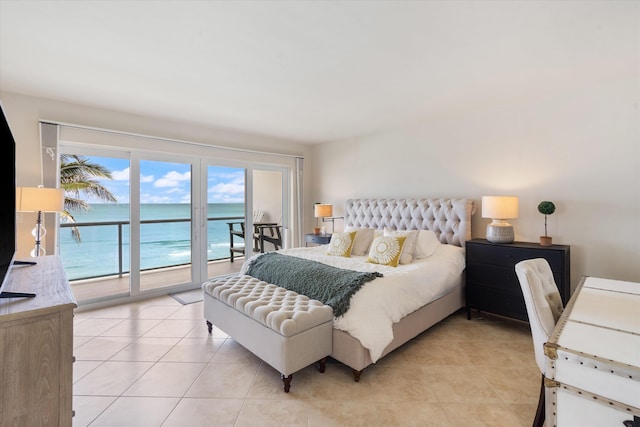 bedroom featuring a water view, light tile patterned floors, and access to outside