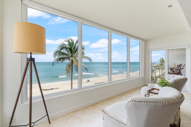 sunroom / solarium with a water view and a view of the beach