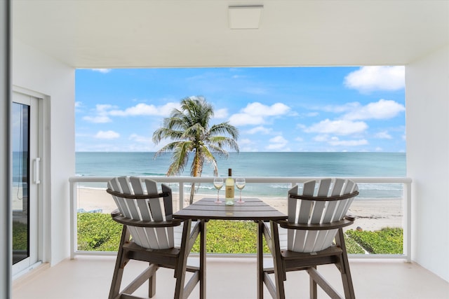 balcony featuring a beach view and a water view