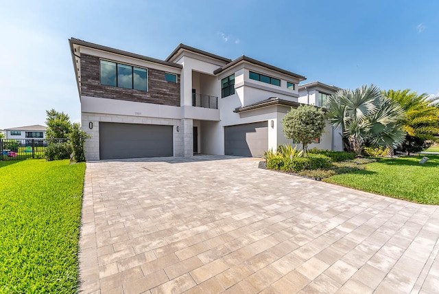 view of front of house with a balcony, a front yard, and a garage