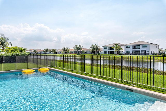 view of pool featuring a yard and a water view