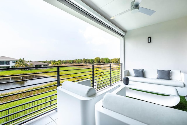 balcony with ceiling fan and a water view