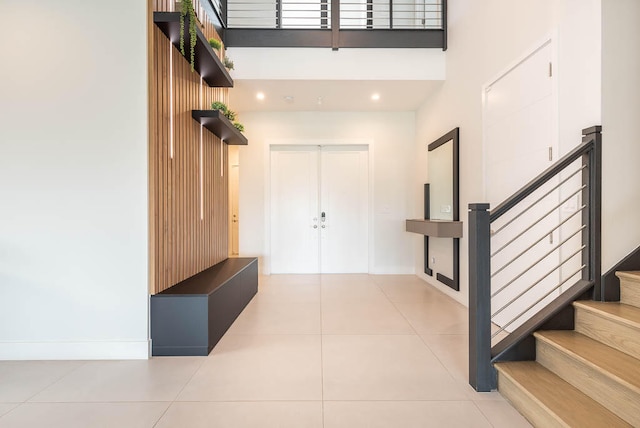 tiled foyer featuring a towering ceiling