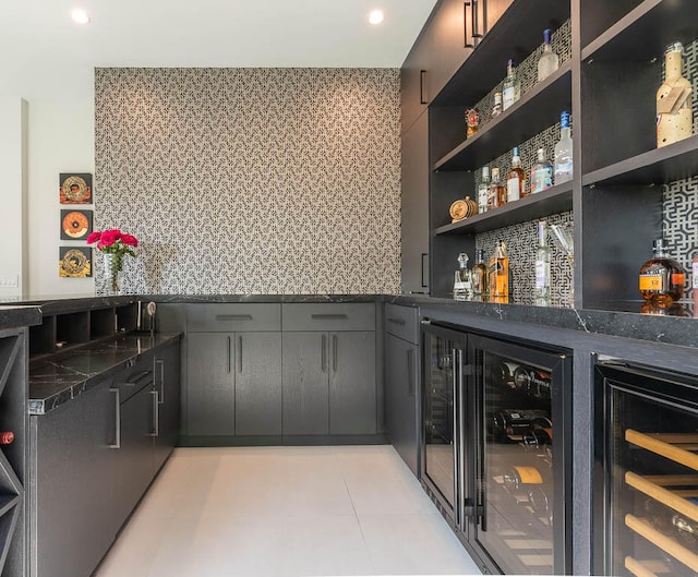 bar with dark stone countertops and wine cooler