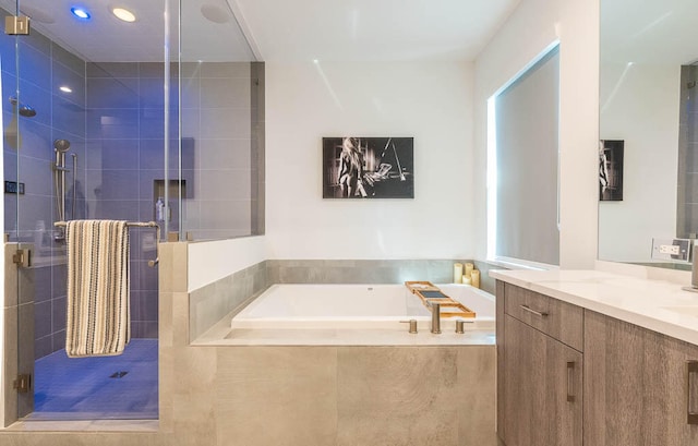 bathroom featuring shower with separate bathtub and vanity