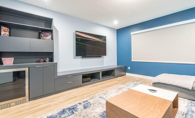 home theater room featuring light hardwood / wood-style floors and wine cooler