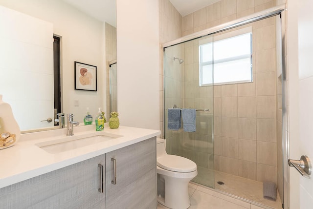 bathroom with tile patterned floors, vanity, toilet, and walk in shower