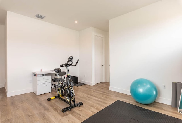 exercise room with light wood-type flooring