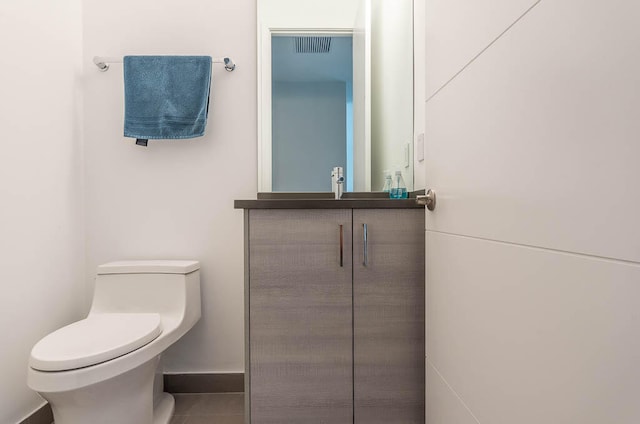 bathroom with tile patterned flooring, vanity, and toilet