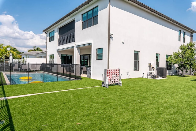 back of house featuring central AC and a yard