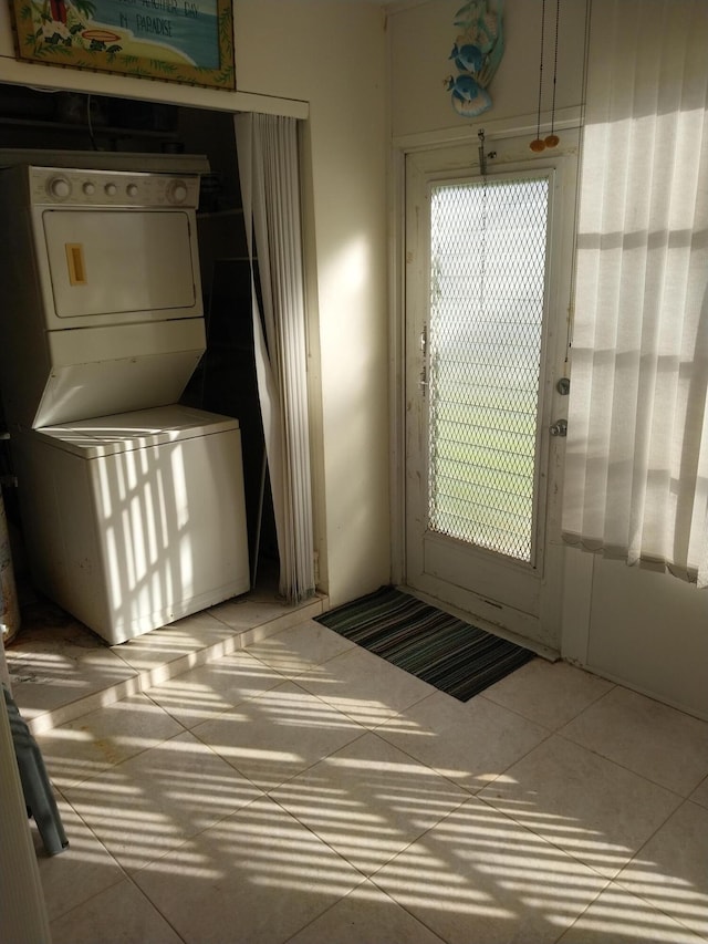 doorway featuring tile patterned floors and stacked washing maching and dryer