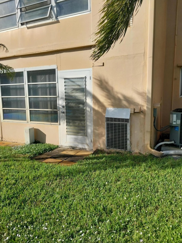 property entrance with a yard and central AC