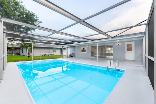 view of swimming pool featuring a yard, a patio area, and glass enclosure