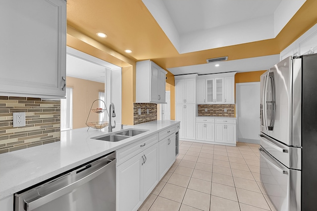 kitchen featuring white cabinets, appliances with stainless steel finishes, backsplash, and sink