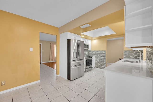 kitchen with decorative backsplash, sink, white cabinets, and stainless steel appliances