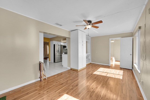 spare room with ceiling fan and light wood-type flooring