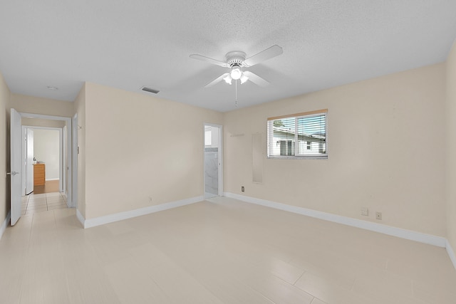 unfurnished room with ceiling fan and a textured ceiling