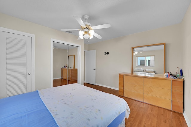 bedroom featuring ceiling fan, two closets, and hardwood / wood-style flooring