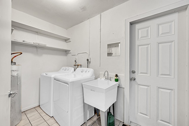 clothes washing area featuring light tile patterned flooring, sink, and washing machine and clothes dryer