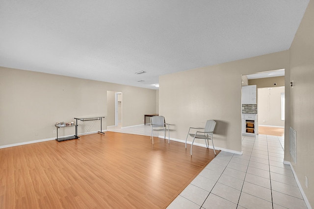 unfurnished room with a textured ceiling and light wood-type flooring