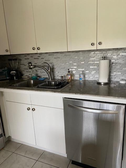 kitchen featuring a center island, backsplash, light carpet, white cabinetry, and stainless steel appliances