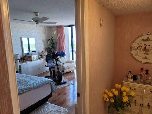 bedroom featuring wallpapered walls, multiple windows, and a textured ceiling