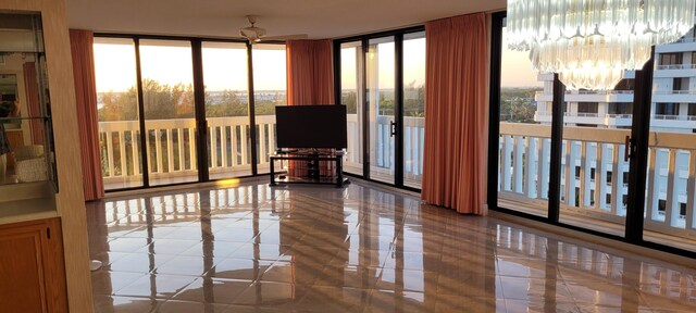 living room with a textured ceiling, ceiling fan, a healthy amount of sunlight, and floor to ceiling windows