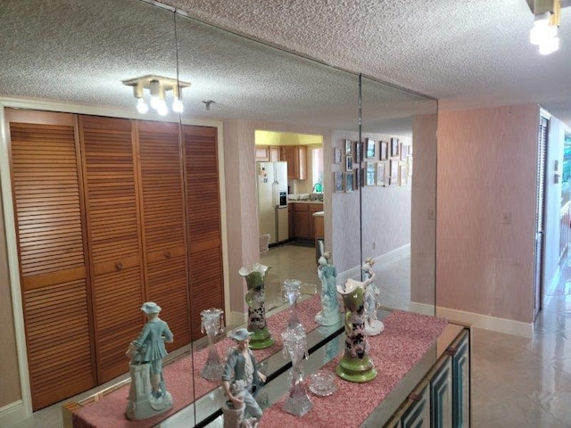 dining room featuring a textured ceiling and baseboards