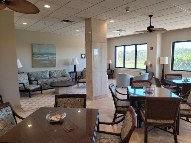 dining area featuring visible vents, a healthy amount of sunlight, ceiling fan, and a drop ceiling