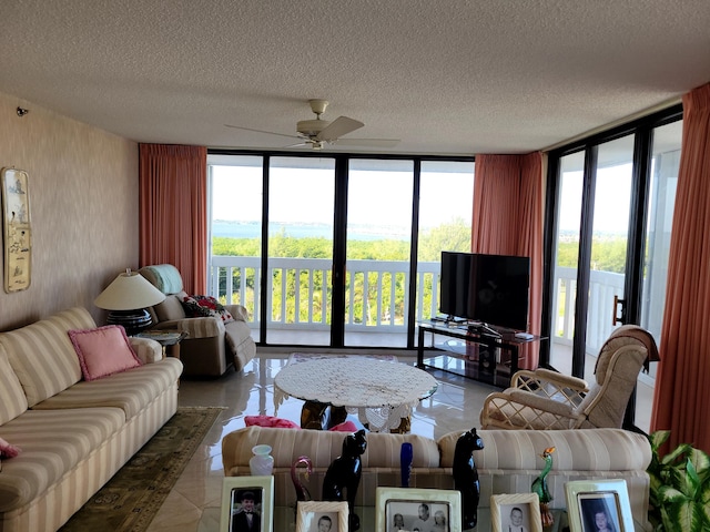 living room with a textured ceiling, a wall of windows, and ceiling fan