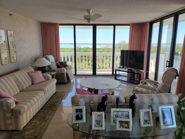 living room featuring a wall of windows, plenty of natural light, and ceiling fan