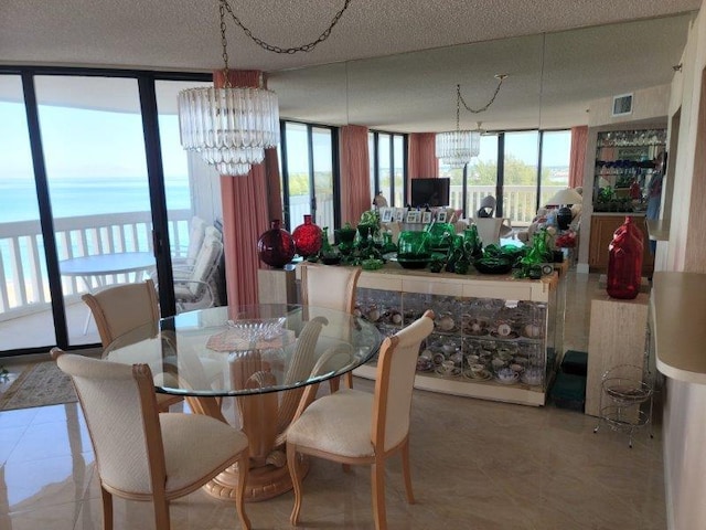 tiled dining room with a wealth of natural light, visible vents, and an inviting chandelier