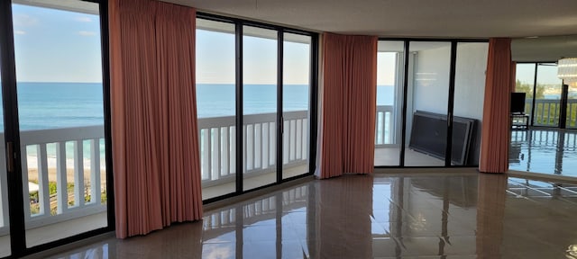 tiled empty room with a wealth of natural light and a water view