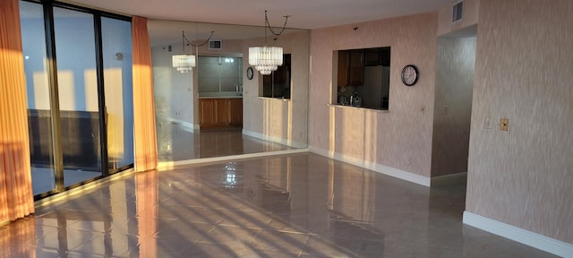 interior space with wallpapered walls, baseboards, visible vents, and a chandelier