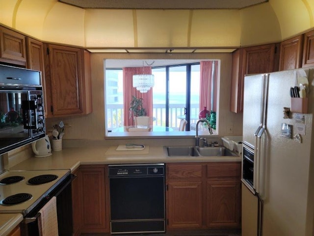 kitchen with a chandelier, sink, and black appliances