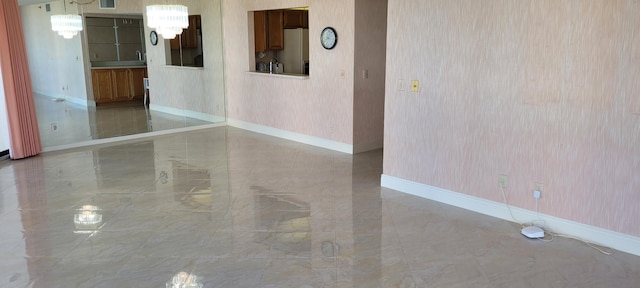 spare room with visible vents, baseboards, wallpapered walls, a notable chandelier, and marble finish floor