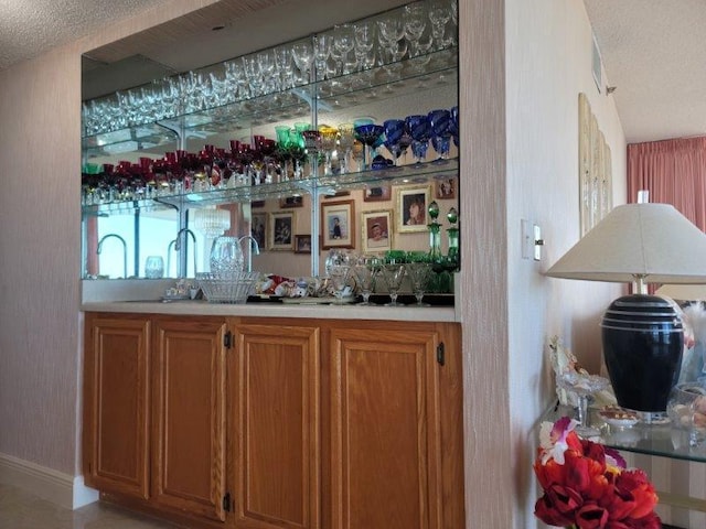 bar with wet bar and a textured ceiling