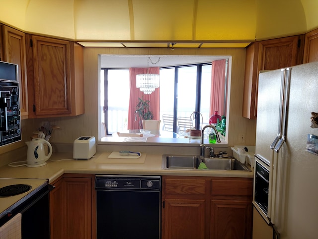 kitchen with black appliances, brown cabinetry, light countertops, and a sink