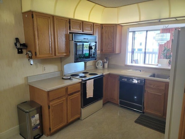 kitchen with dishwasher, light countertops, light tile patterned floors, brown cabinets, and electric stove