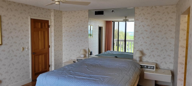 bedroom with access to exterior, visible vents, and wallpapered walls