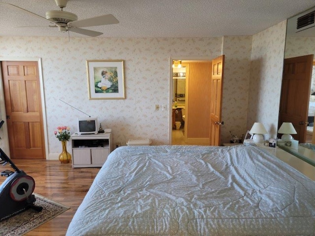 bedroom featuring wood-type flooring, a textured ceiling, and ceiling fan