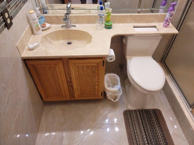 bathroom featuring toilet, vanity, and a shower stall