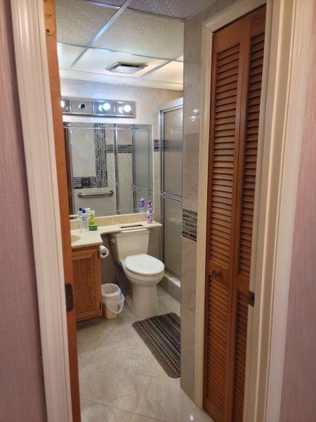 full bath featuring tile patterned floors, toilet, a closet, a shower stall, and vanity