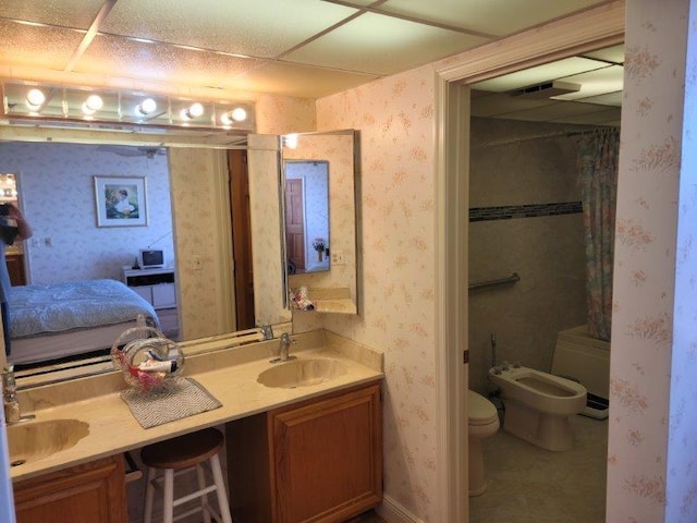 full bathroom with a sink, a bidet, double vanity, and wallpapered walls