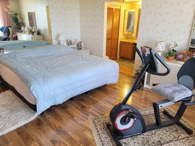 bedroom featuring light wood-style flooring and wallpapered walls