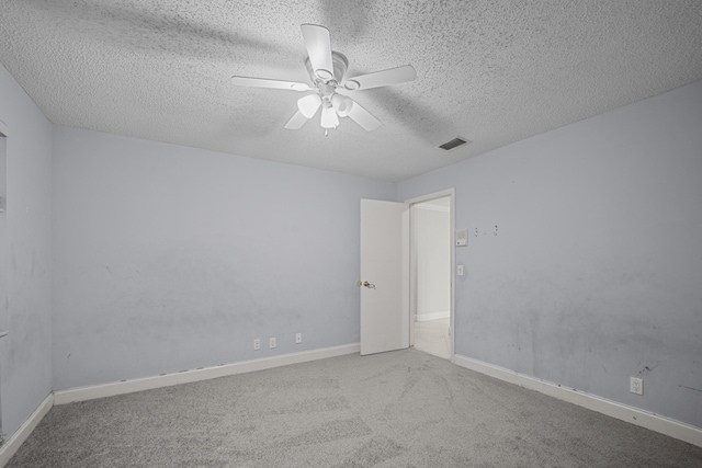 carpeted spare room featuring ceiling fan and a textured ceiling