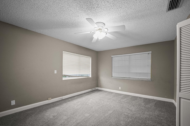 unfurnished bedroom with a textured ceiling, carpet floors, and ceiling fan